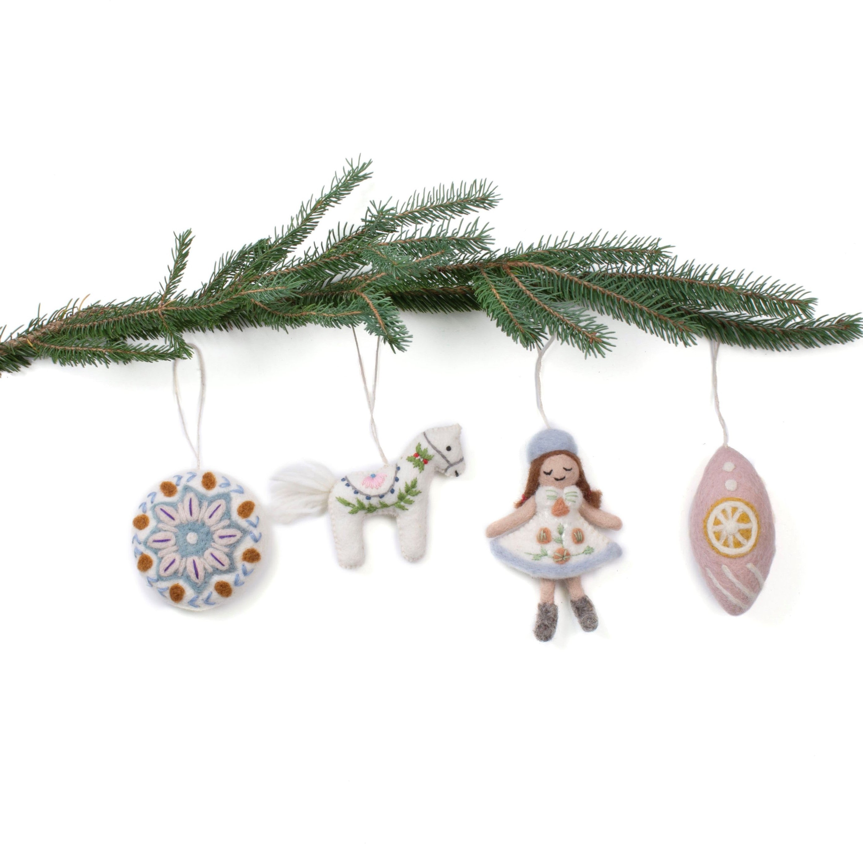 Set of four hand-felted wool Christmas ornaments including a snowflake medallion, prancing pony, frosted girl, and lemon-slice bauble in soft pastel tones, handmade in Nepal through Fair Trade craft